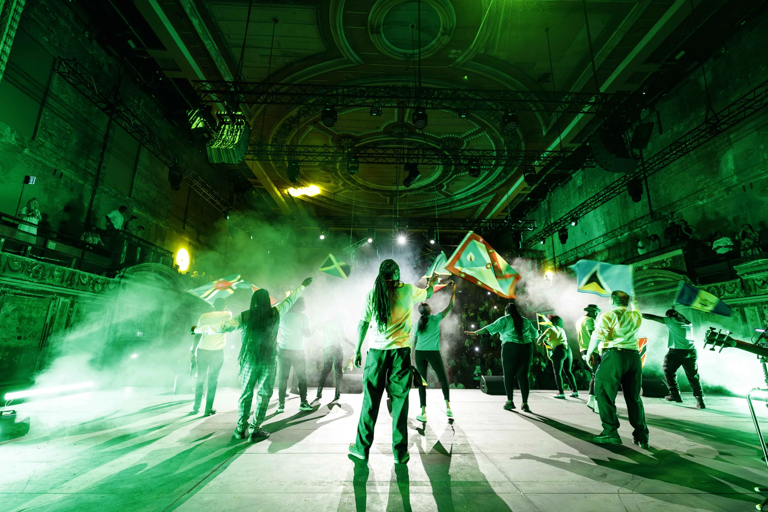 Jamaica Love stage production with performers waving Caribbean flags